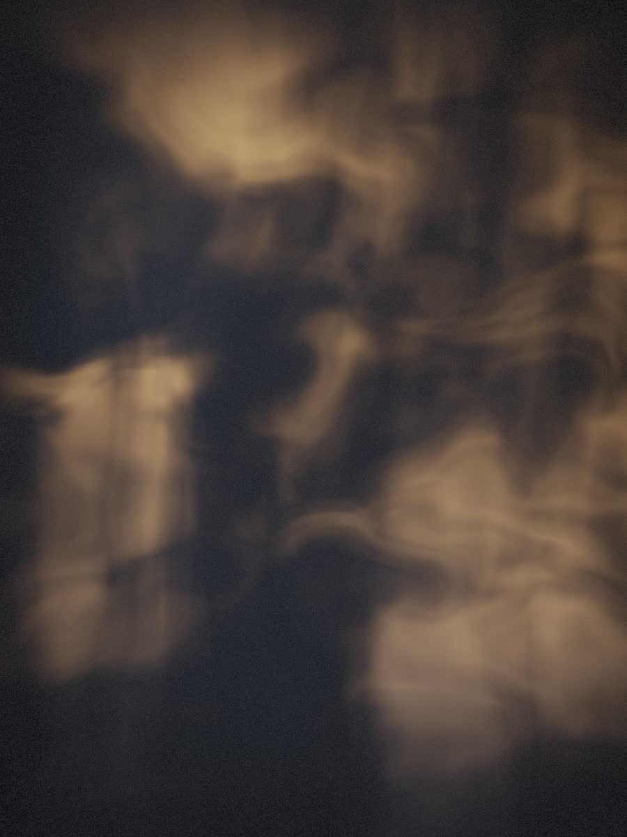 Volumetric amber haze curling through a dark chamber.
